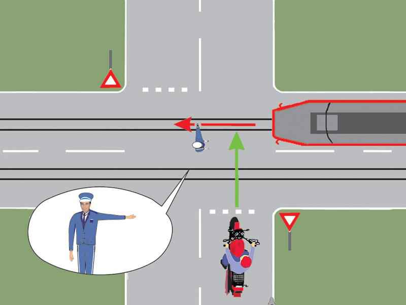 Whom does the traffic police officer in the intersection allow to pass?
